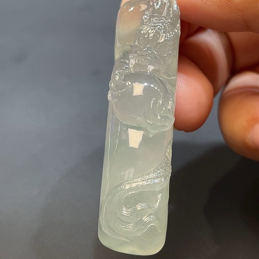 這款天然A級翡翠龍戲珠吊墜（編號#256），以細膩通透的翡翠雕刻而成，呈現祥龍翻騰戲珠的生動場景，氣勢磅礡、栩栩如生。龍象徵權威與吉運，戲珠寓意智慧與圓滿，整體設計蘊含祥瑞之意。佩戴此吊墜，不僅彰顯品味，更寓意事業飛騰、福氣盈門。