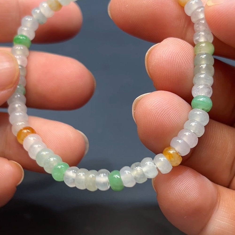 這款天然A級翡翠多寶算盤珠手串（編號#263），以多種色澤的迷你翡翠珠精巧串製而成，包含陽綠、油青、紫羅蘭等多色珠粒，尺寸雖小卻飽滿圓潤。算盤珠象徵財運與智慧，串成多寶更寓意福氣連綿、五福齊聚。設計小巧精緻，適合細腕佩戴，盡顯低調優雅與豐富寓意。