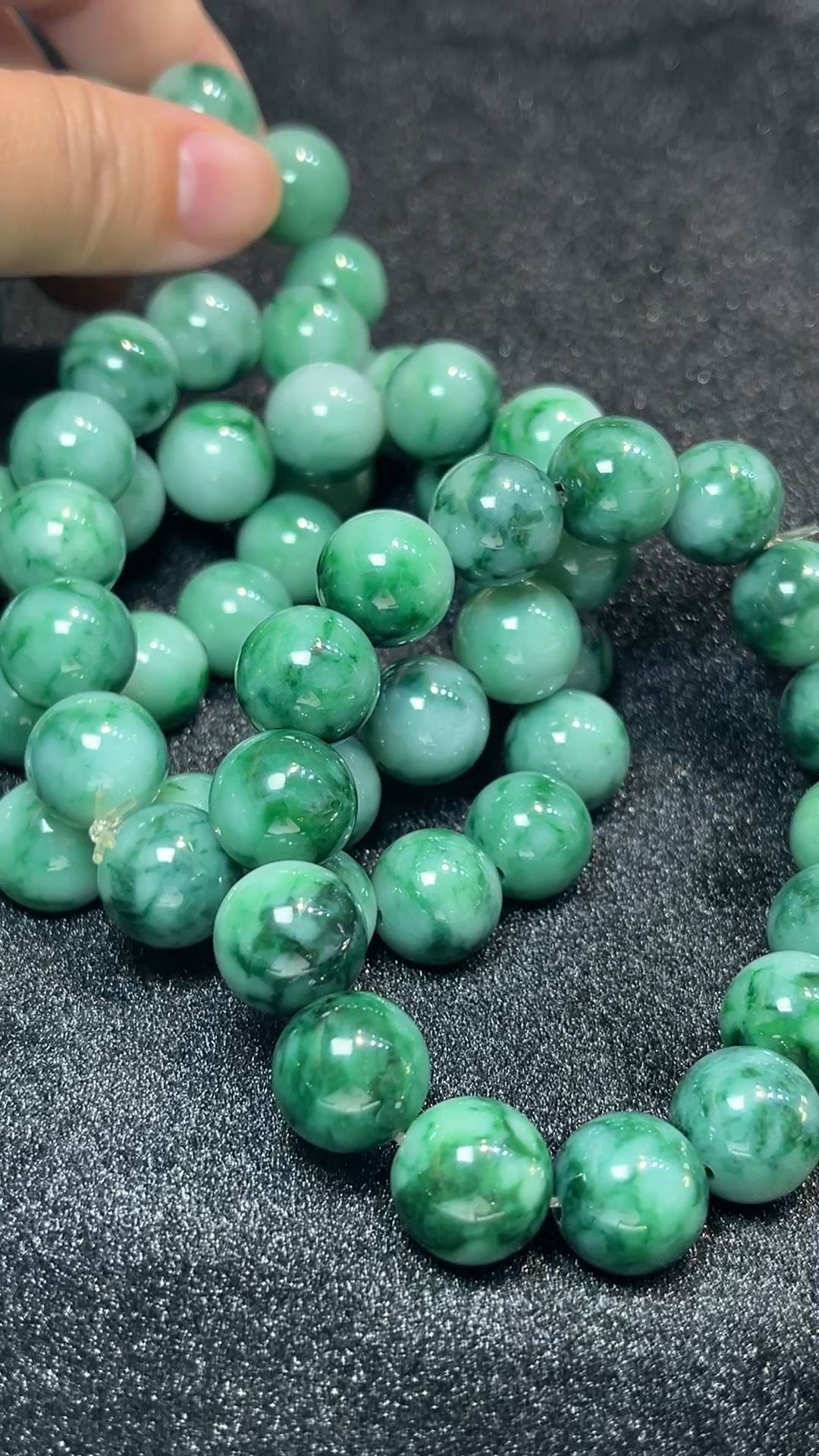 天然A級翡翠 水墨風華|天然花青翡翠手串珍品 翡翠直播#265 1 這款天然A級翡翠花青圓珠手串(編號#265),選用質地細膩的花青翡翠珠串製而成,色澤呈自然墨綠與淺白交融,似山水意境般層次分明。每顆珠子圓潤飽滿,飄逸的花紋如水墨流轉,低調中展現高雅氣韻。花青翡翠寓意穩重與智慧,適合日常佩戴,亦具品味與文化象徵。