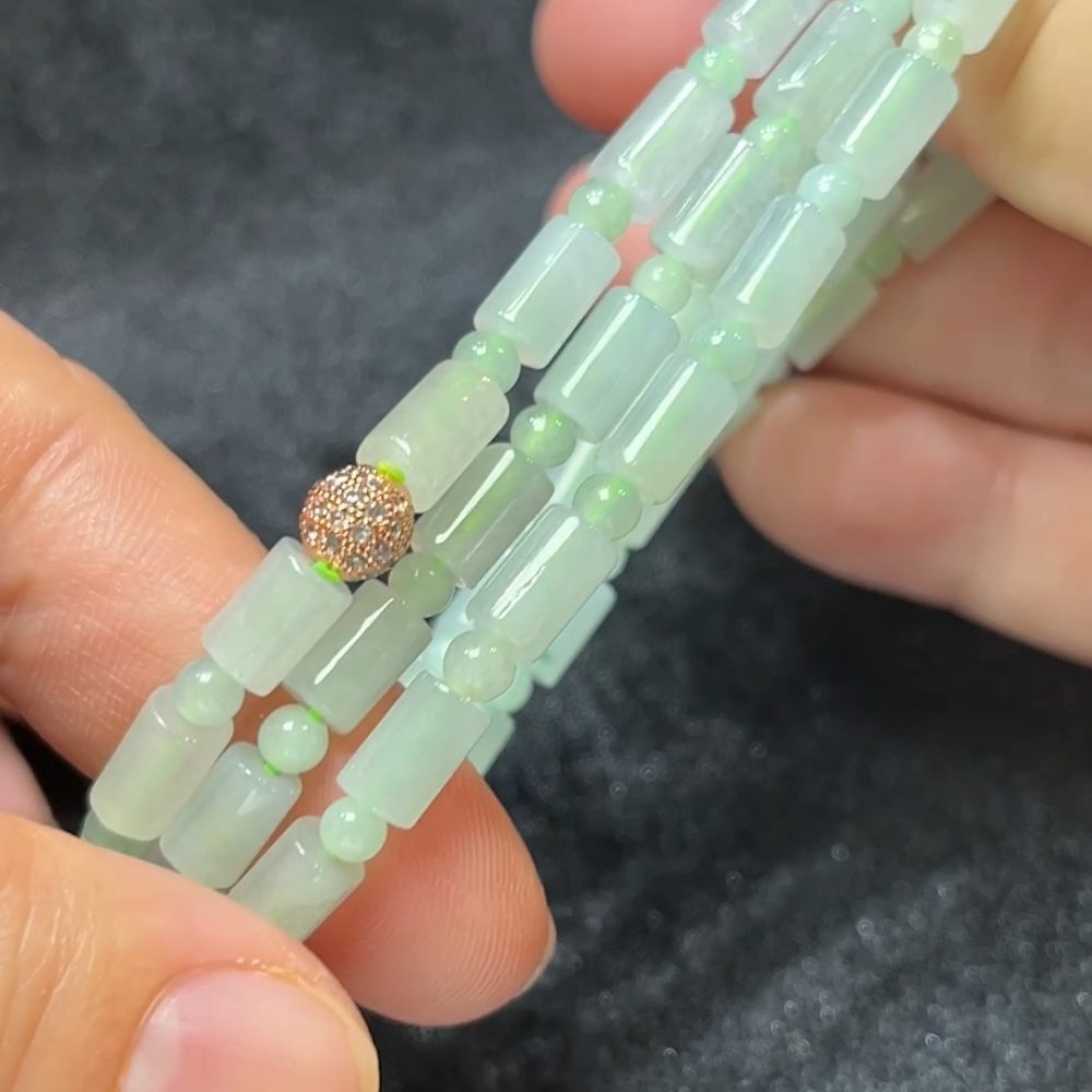 這款天然A級翡翠長形桶珠項鏈（編號#271），匠選通透溫潤的長條形翡翠桶珠搭配圓珠間隔串製，整體線條流暢而富層次感。長形桶珠修長優雅，象徵事業順利、步步高昇；而圓珠點綴則增添圓融與平衡之意。色澤自然協調，融合清新陽綠、淡青與白冰等典雅色系，展現清麗脫俗的氣質。佩戴此項鏈，不僅提升氣場，更寓意福慧兼備、吉祥長存。