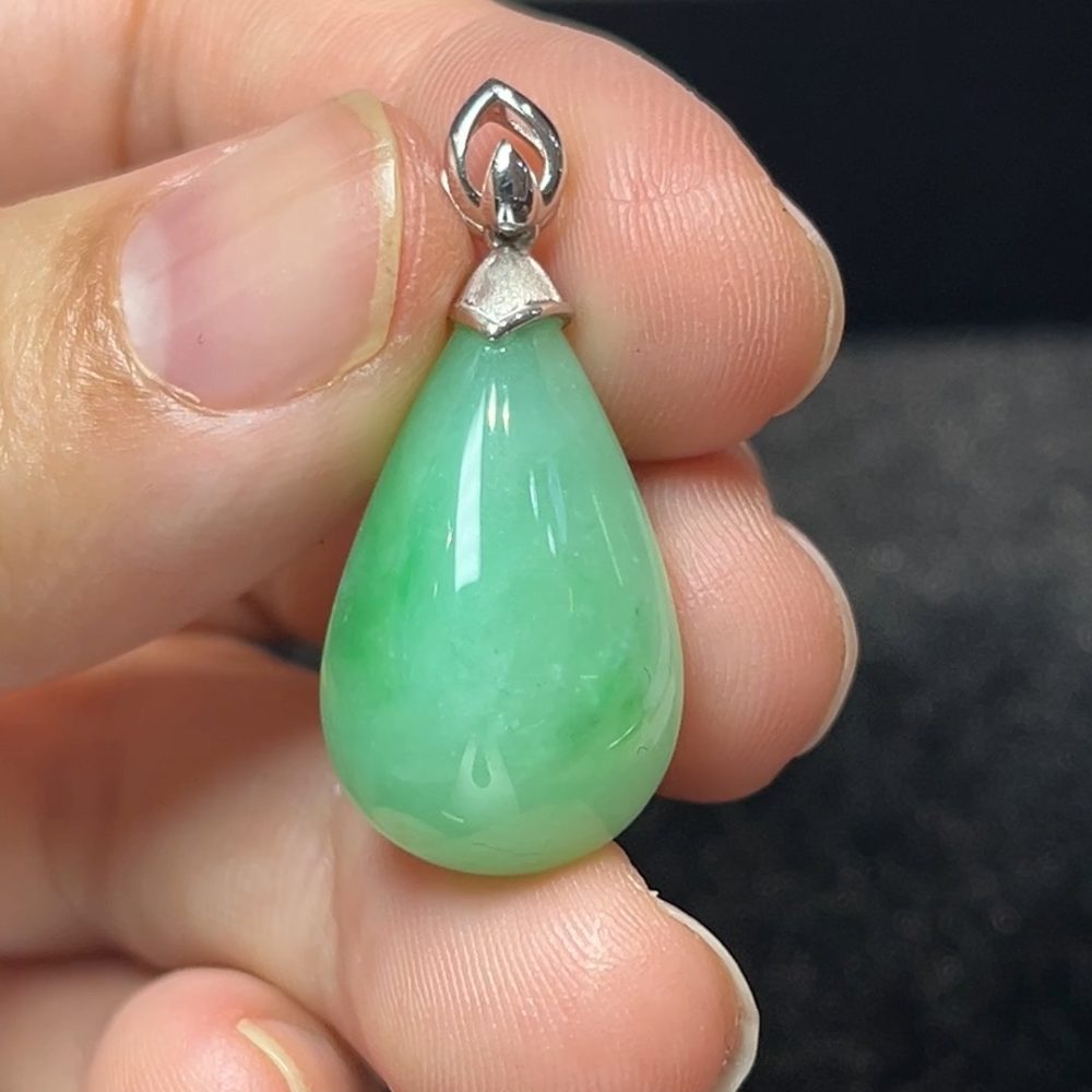 這款天然A級翡翠淺綠水滴吊墜（編號#274），選用色澤清透柔和的淺綠翡翠，雕成經典水滴造型，象徵自然純淨與溫柔力量。搭配18K白金精緻鑲嵌設計，線條優雅流暢，襯托翡翠的細膩光澤與溫潤質感，整體造型現代而不失東方韻味。淺綠翡翠寓意新生、清明與希望，佩戴此吊墜可提升氣質與親和力，亦是送禮祝福的優雅之選。