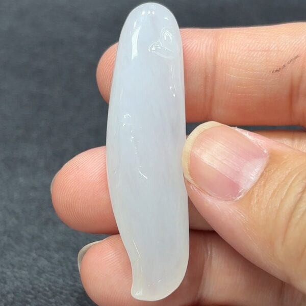 這件白色翡翠隨形悟道,無規則的自然造型猶如雲煙飄渺,寓意隨緣自在、不拘一格。白玉清透靜雅,彷彿映照出一份純粹心境,令人由物觀心,由玉悟道。整體線條流暢柔和,保留天然石紋與圓潤感,予人空靈沉穩的感受。此件玉器不僅展示自然美學與工藝融合,更是象徵修行中「無我」、「無相」的境界。無論佩戴或擺放,皆是一份靜心之選,可喻為生活中尋求安定與智慧的指南。