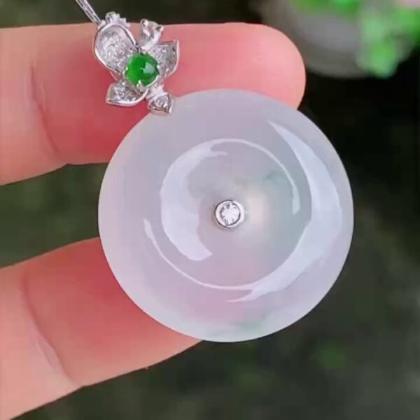 本品尺寸為 22.3 × 6.2mm，種水與色澤表現卓越。工藝細節方面，這件白色翡翠平安扣的玉水頭很好，種質細膩，質地極為乾淨，在微光下呈現出瑩潤如脂、起冰浮光的優質底色。匠人精心考究比例，將扣身打磨得飽滿對稱，線條流暢流暢。上方的 18K 白金花頭設計扣頭工藝極其細緻，花瓣線條生動立體，與結構穩固的白金鑲嵌緊密契合，既完美保護了嬌貴的翡翠，又極大地提升了高級珠寶的層次感。本品隨貨附送權威的香港翡翠鑑定證書，確保天然品質，讓您安心收藏。